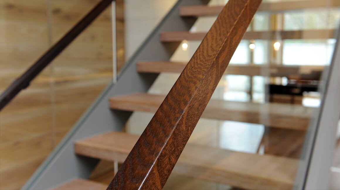 Geschosstreppe mit Trittstufen aus Buchenholz und Handlauf aus Macassar-Ebony.